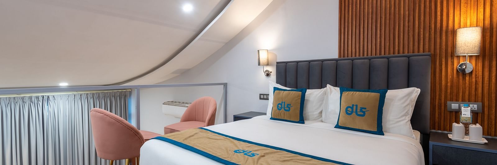 Spring Duplex Room at DLS Spring  Valley resort Dharamshala on the second story featuring a king bed table, chairs and a  bed lamp